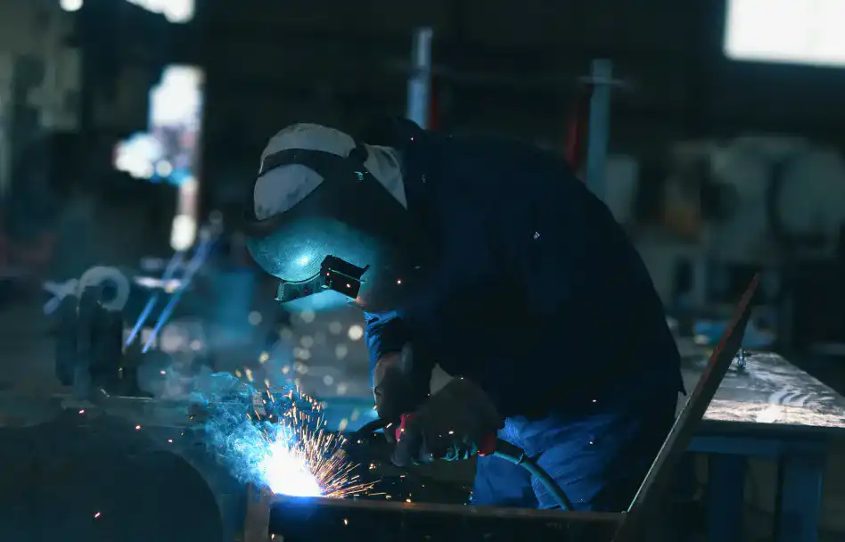 青白い火花を散らしながら大型の鉄骨を溶接する職人：株式会社Steelの製造現場