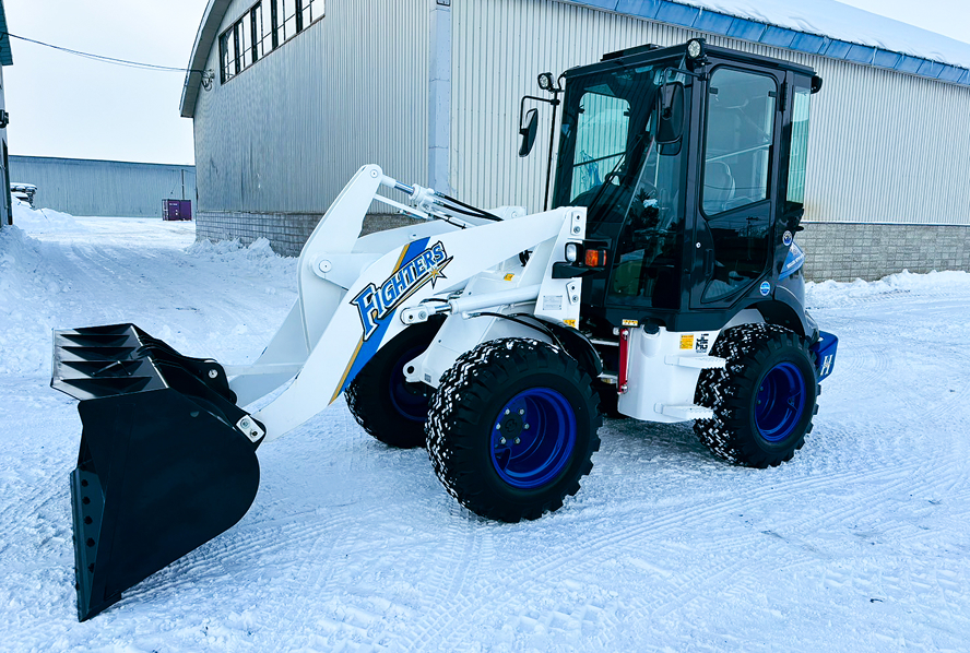 北海道日本ハムファイターズ仕様のカスタムペイントが施された、除雪・資材搬送用ホイールローダー。